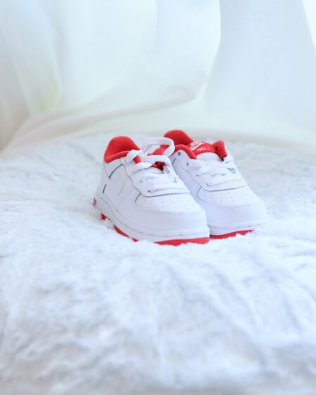 white and red nike sneakers on white textile