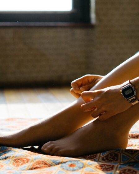 person sitting on orange and blue area rug