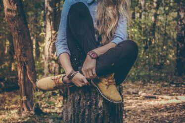 woman sitting on tree stump